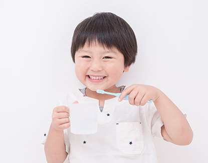 子供が笑顔で歯磨きをしている写真